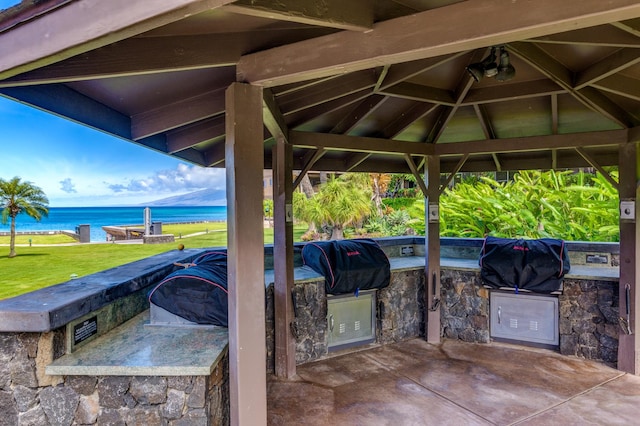 view of patio / terrace with a gazebo, an outdoor kitchen, a grill, and a water view