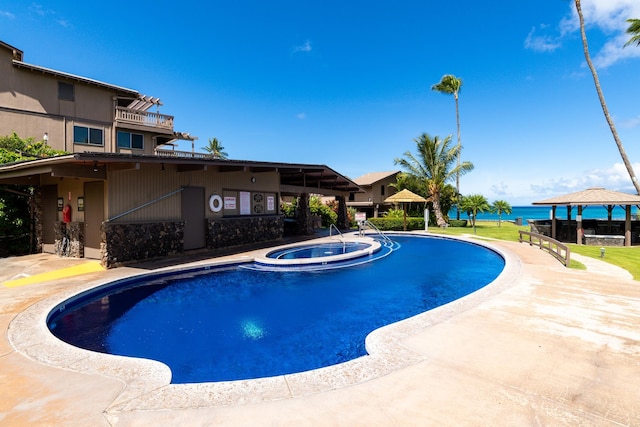 view of swimming pool featuring an in ground hot tub, a gazebo, and a water view