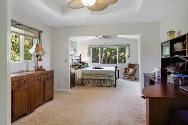 bedroom featuring a tray ceiling, light colored carpet, baseboards, and ceiling fan