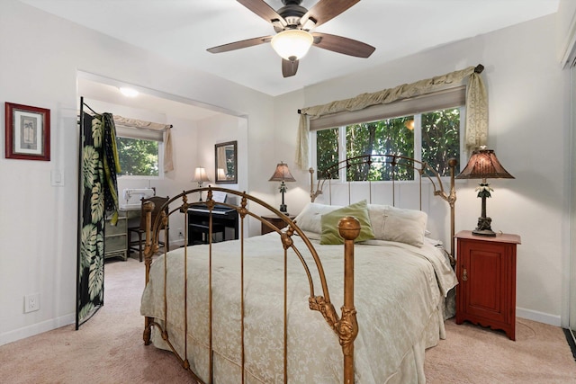 bedroom with light colored carpet, a ceiling fan, and baseboards