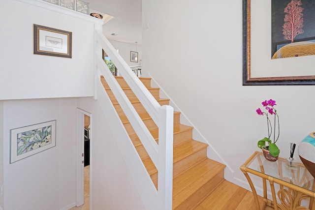 stairs featuring wood finished floors and baseboards