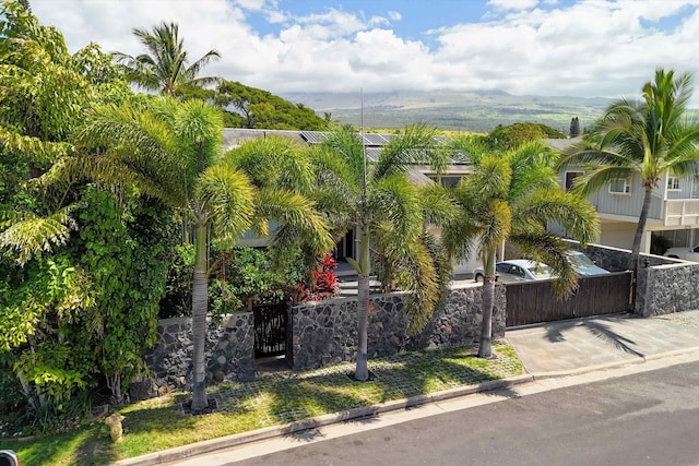 exterior space with a fenced front yard, concrete driveway, and a gate