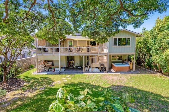 rear view of property featuring a yard, a patio area, a deck, and a hot tub