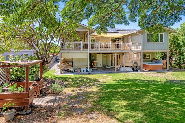 back of house with solar panels, a vegetable garden, a yard, a hot tub, and a patio area