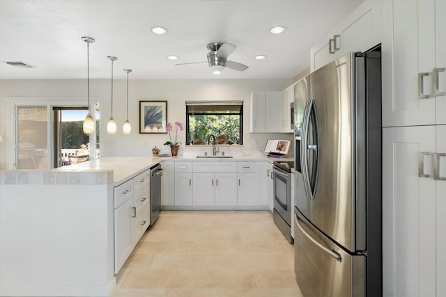 kitchen with visible vents, a sink, white cabinetry, stainless steel appliances, and a peninsula