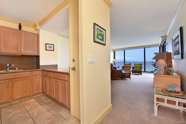 110 Kaanapali Shores Pl Unit 817, Lahaina, HI 96761 - kitchen with a sink, decorative backsplash, ornamental molding, light colored carpet, and dark countertops