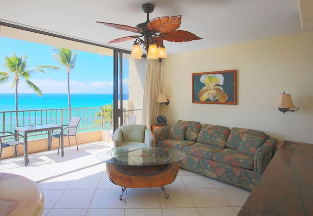 living room featuring a water view, light tile patterned floors, and ceiling fan