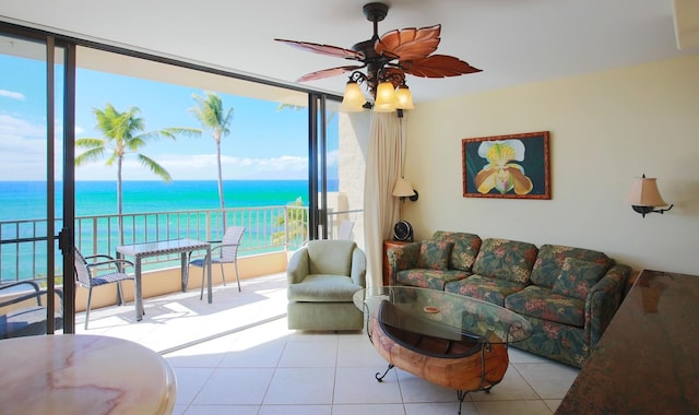 tiled living room featuring ceiling fan and a water view