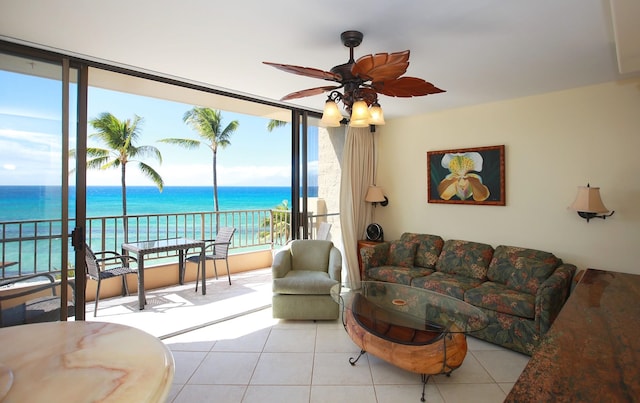 living room featuring a water view, light tile patterned floors, and ceiling fan