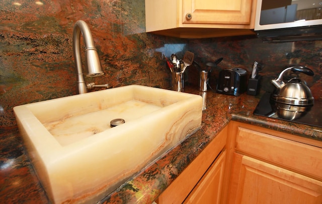 room details with light brown cabinets, sink, and tasteful backsplash