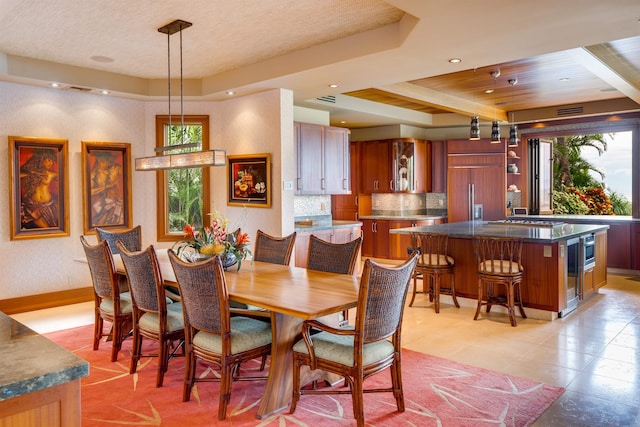 dining room featuring a raised ceiling and a healthy amount of sunlight