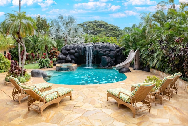 view of pool featuring an in ground hot tub, pool water feature, a water slide, and a patio area