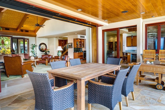 dining room with high vaulted ceiling, beverage cooler, ceiling fan, wooden ceiling, and beam ceiling