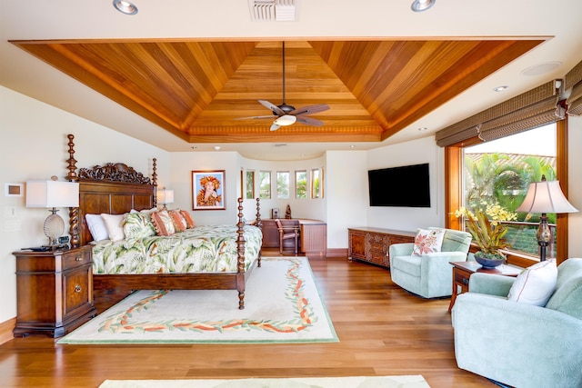 bedroom with multiple windows, a tray ceiling, and wooden ceiling