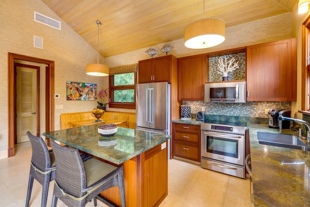 kitchen featuring pendant lighting, sink, a breakfast bar area, appliances with stainless steel finishes, and a center island