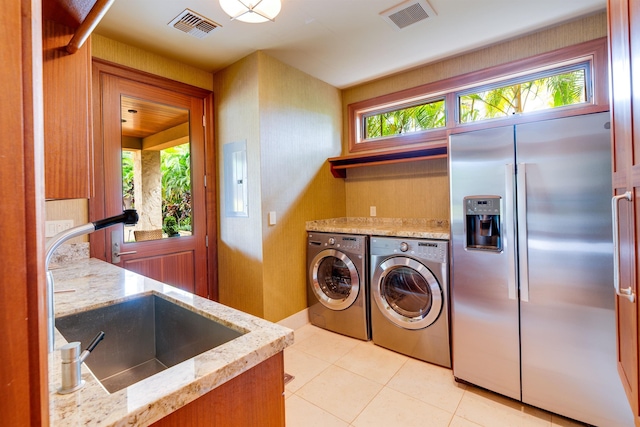 kitchen with sink, light tile patterned floors, washer and clothes dryer, and stainless steel built in fridge