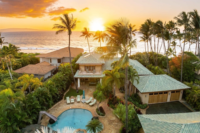 exterior space featuring a water view, a water slide, and a patio area