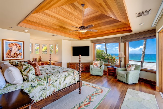 bedroom with a tray ceiling, hardwood / wood-style floors, and wooden ceiling