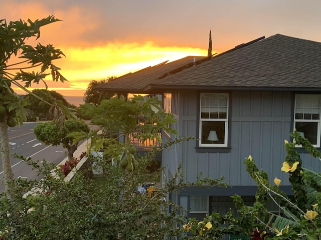 view of side of property featuring a shingled roof and board and batten siding