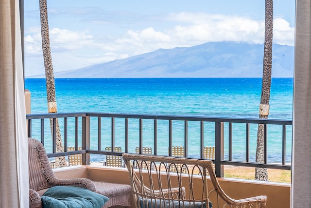 balcony featuring a water and mountain view