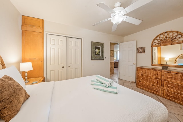 bedroom featuring light tile patterned floors, ceiling fan, and a closet