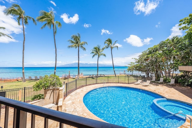 view of swimming pool with a patio and a water view