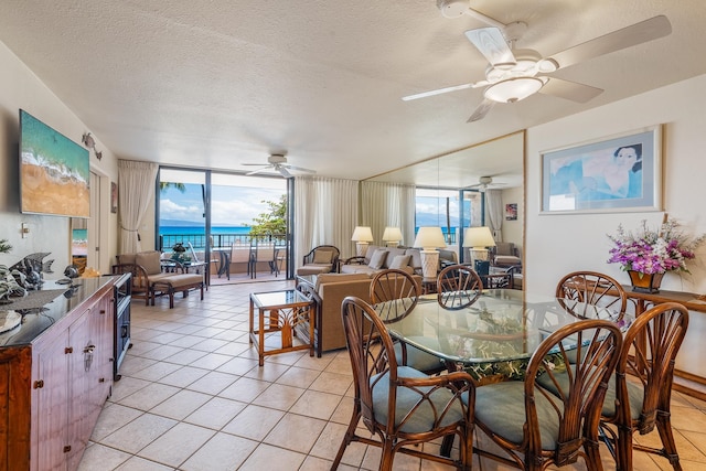 tiled dining area featuring ceiling fan, a textured ceiling, and expansive windows