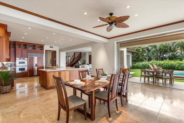 dining space featuring crown molding, ceiling fan, and light tile flooring