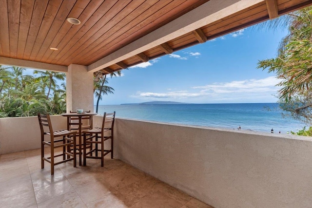 balcony with a water view and a beach view