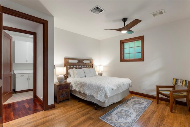 bedroom with connected bathroom, ceiling fan, and light hardwood / wood-style flooring