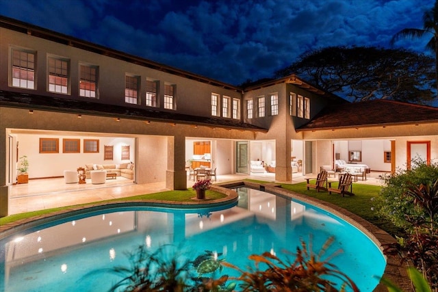 pool at twilight featuring a patio and an outdoor living space