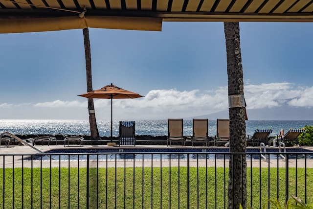 view of pool featuring a water view, a yard, and a view of the beach