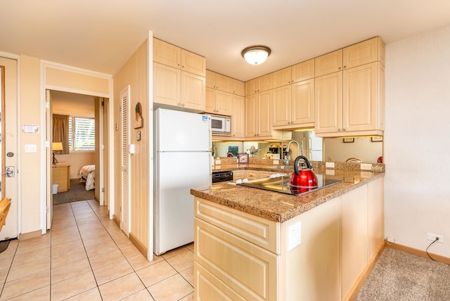 kitchen with light stone counters, kitchen peninsula, white appliances, cream cabinetry, and light tile patterned floors