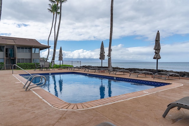 view of pool with a patio area and a water view