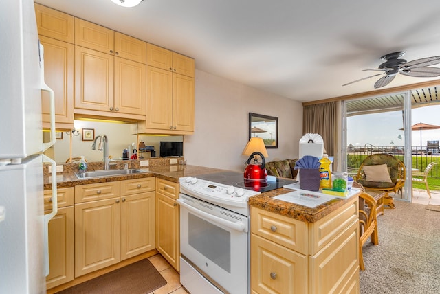 kitchen featuring white appliances, sink, ceiling fan, light colored carpet, and kitchen peninsula