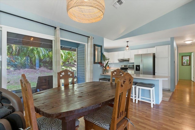 dining area with light hardwood / wood-style floors and lofted ceiling