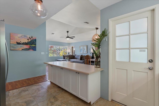 kitchen with ceiling fan, white cabinets, and vaulted ceiling