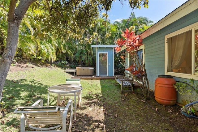 view of yard featuring a storage shed and a hot tub