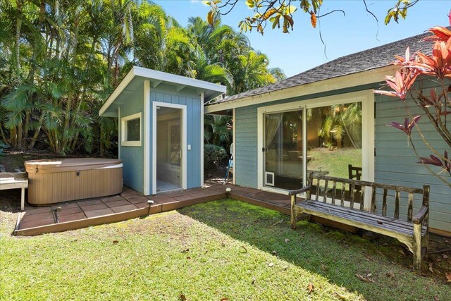 view of outbuilding with a hot tub and a yard