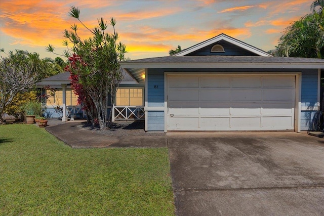 ranch-style house with a garage and a yard