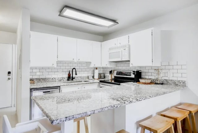 3740 Lower Honoapiilani Rd Unit B103, Lahaina, HI 96761 - kitchen with stainless steel appliances, a sink, tasteful backsplash, and a peninsula
