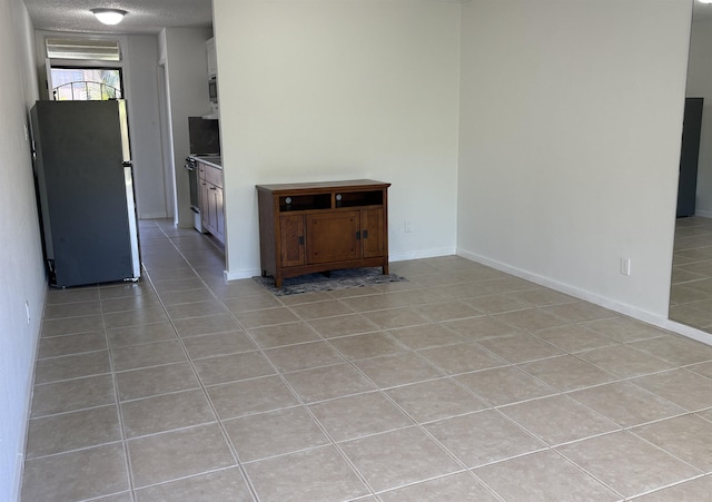 715 S Kihei Rd Unit D143, Kihei, HI 96753 - unfurnished living room featuring light tile patterned floors, baseboards, and a textured ceiling