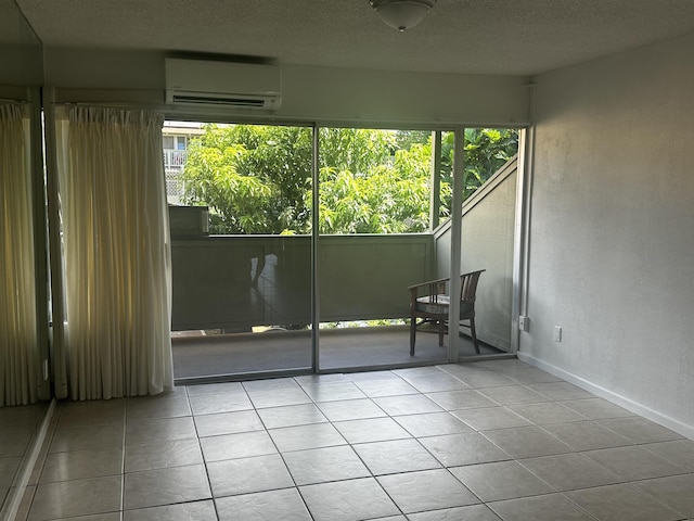 715 S Kihei Rd Unit D143, Kihei, HI 96753 - tiled spare room with a wall mounted AC, healthy amount of natural light, baseboards, a textured ceiling, and a textured wall