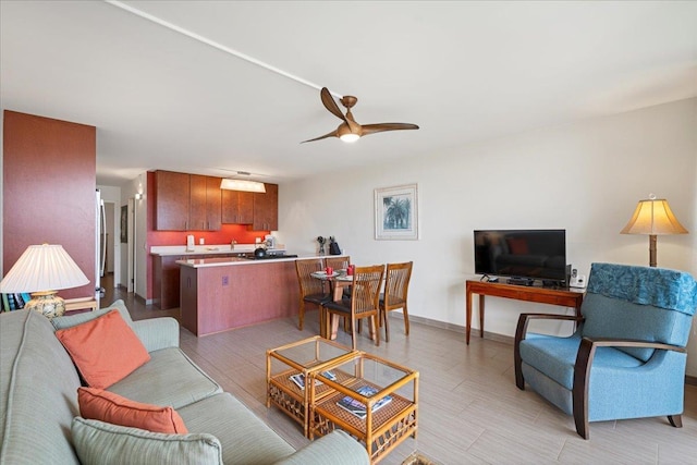 living room with ceiling fan and baseboards