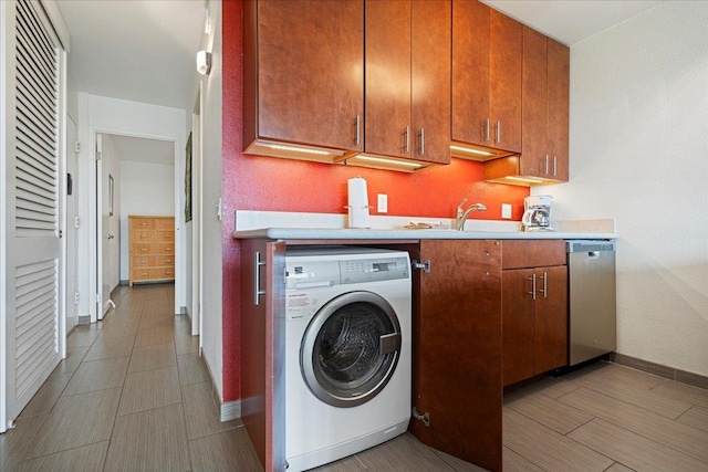 laundry area featuring washer / clothes dryer, baseboards, and a sink