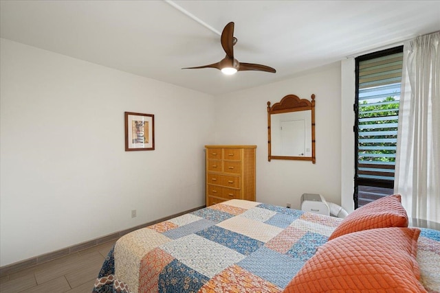bedroom with a ceiling fan, baseboards, and wood finished floors