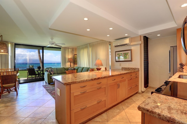 kitchen featuring ceiling fan, light tile patterned floors, light stone counters, a peninsula, and light brown cabinets