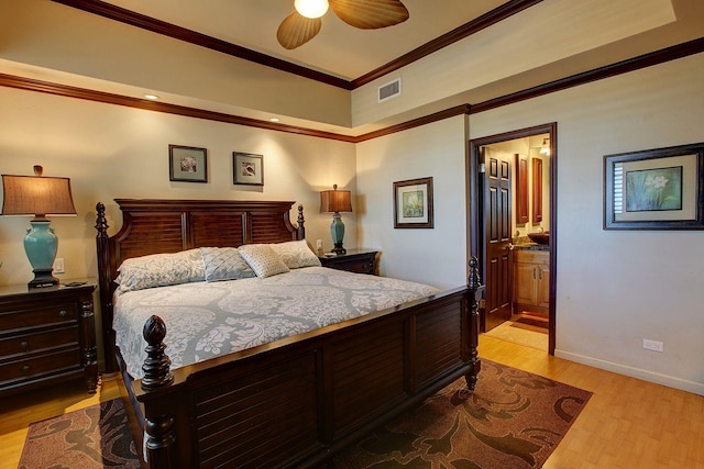 bedroom featuring ensuite bath, ceiling fan, light hardwood / wood-style flooring, and ornamental molding