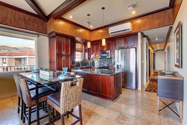 kitchen featuring pendant lighting, dark stone counters, an AC wall unit, appliances with stainless steel finishes, and a kitchen island