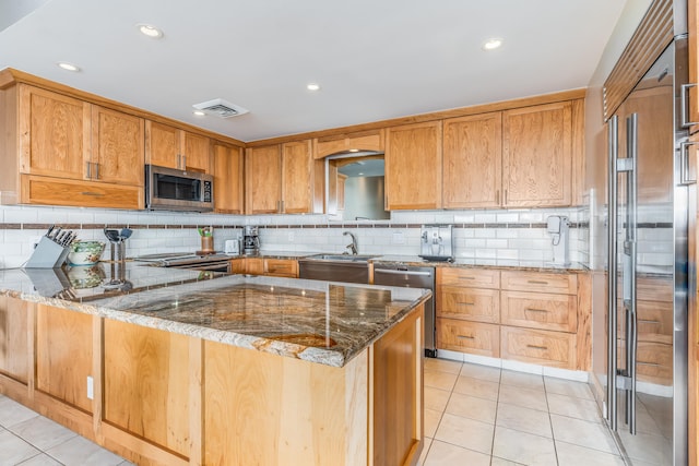 kitchen featuring appliances with stainless steel finishes, tasteful backsplash, sink, stone countertops, and light tile patterned floors